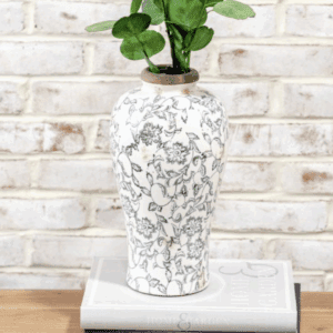 White ceramic vase with gray marbled pattern holding green leaves.